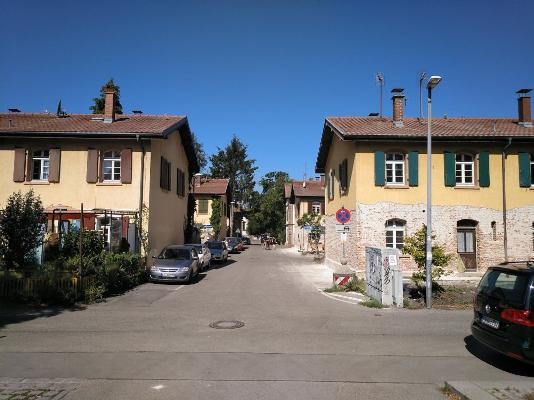 Knopfhäuslesiedlung Straßenzug mit 2 geschossiger Wohnblockbebauung rechts und links der Straße