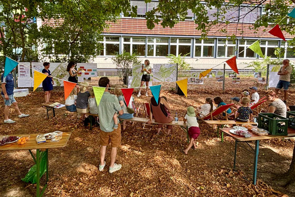 Erwachsene und Kinder bei einer Infoveranstaltung im Freien