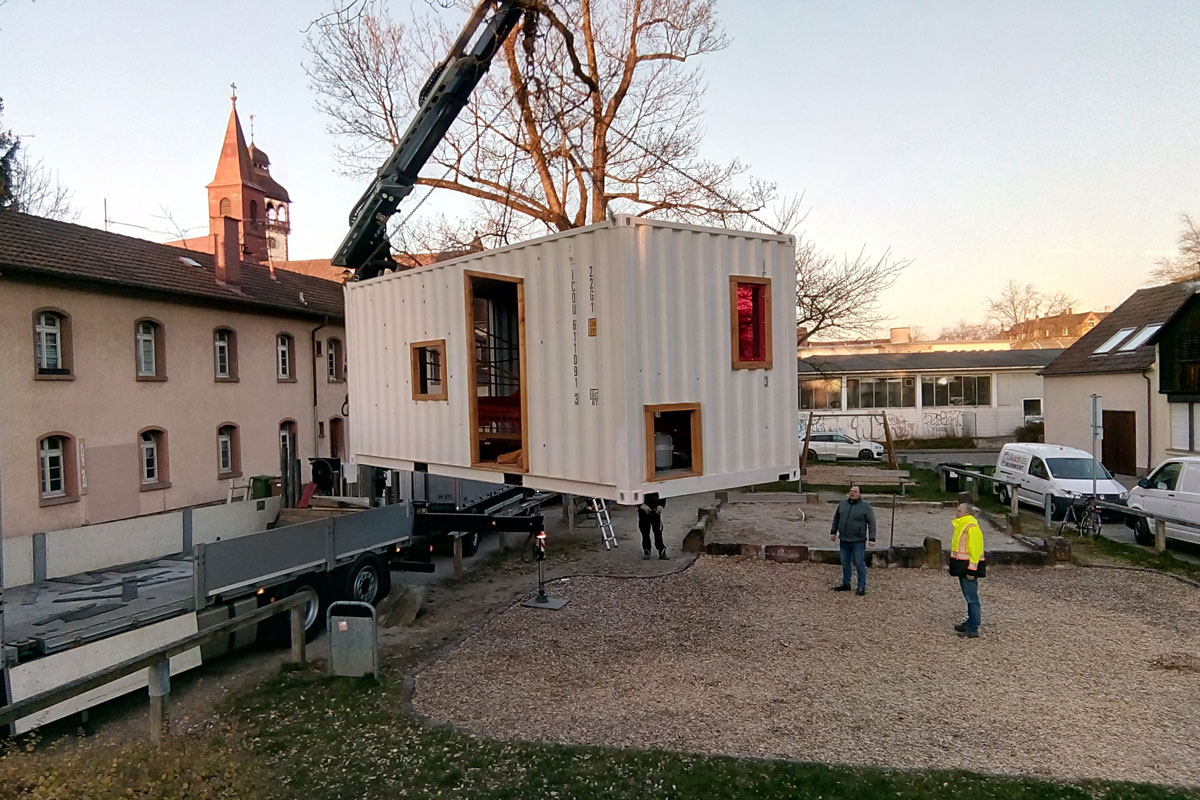 Die Wanderbox wird an einem Kran auf den Spielplatz gestellt