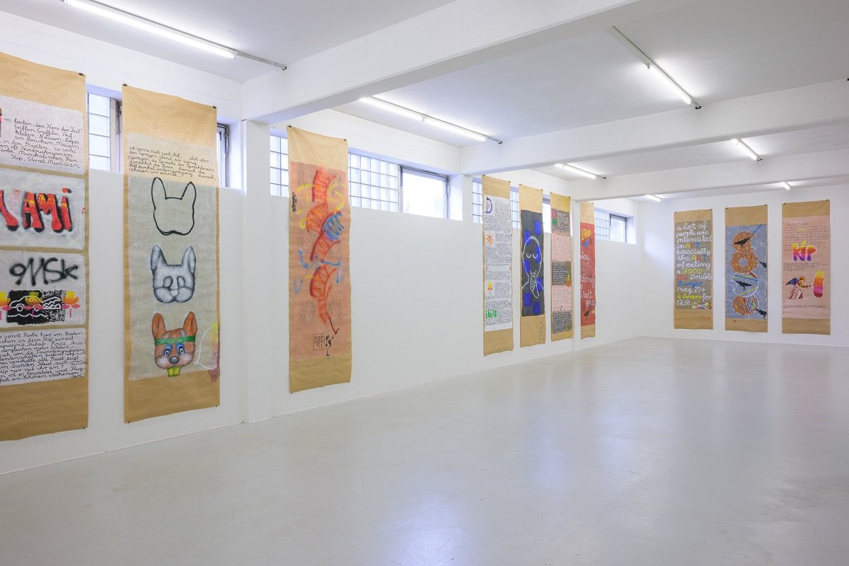 Ausstellungsansicht Kirti Ingerfurth: bemalte Packpapierbahnen mit Texten