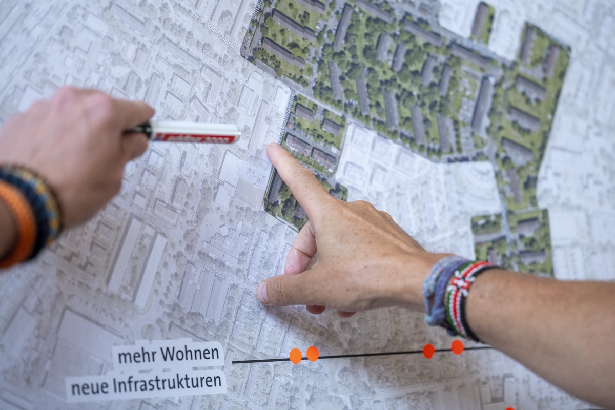 Hände zeigen auf einen Plan des Quartiers