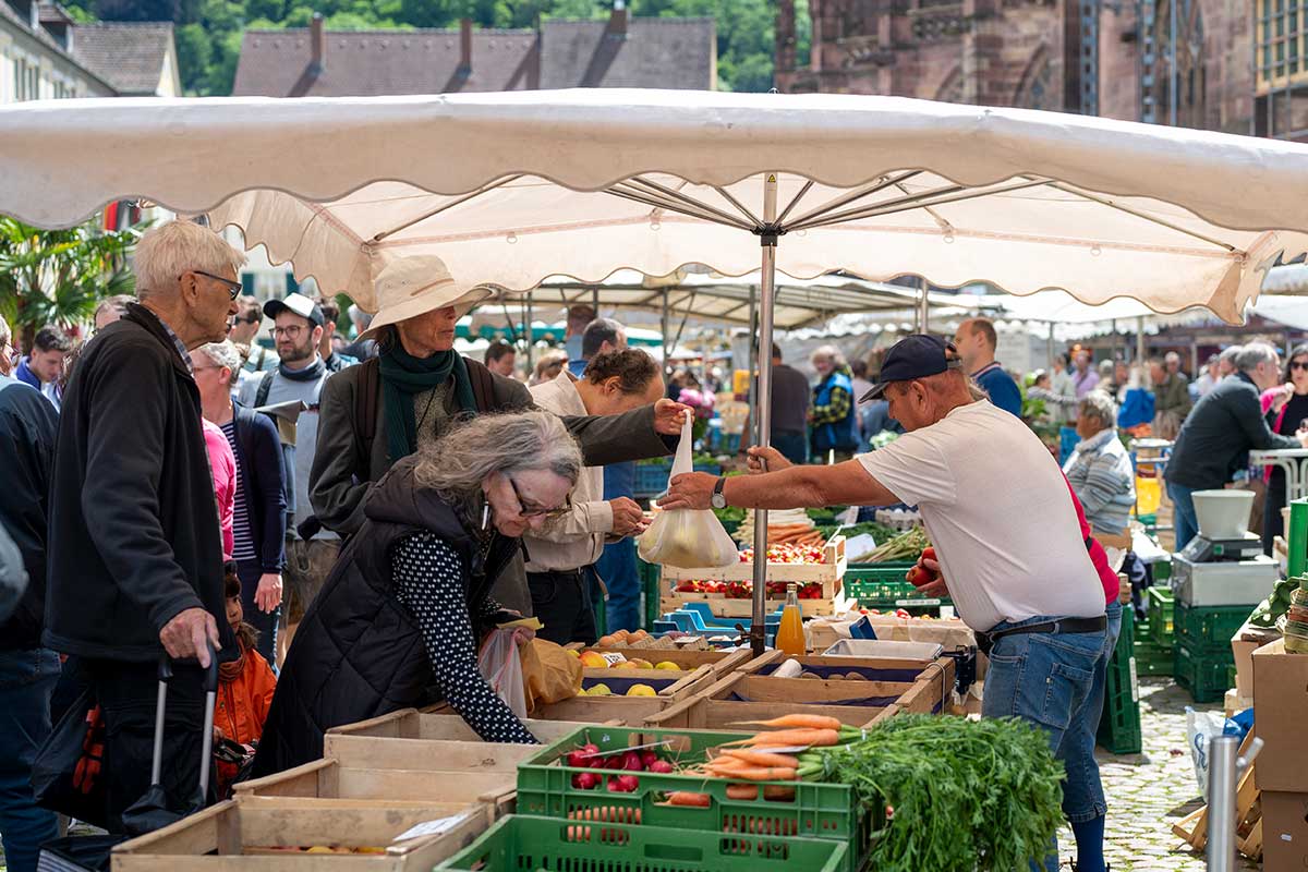 Landwirt und Kund*innen auf dem Münstermarkt
