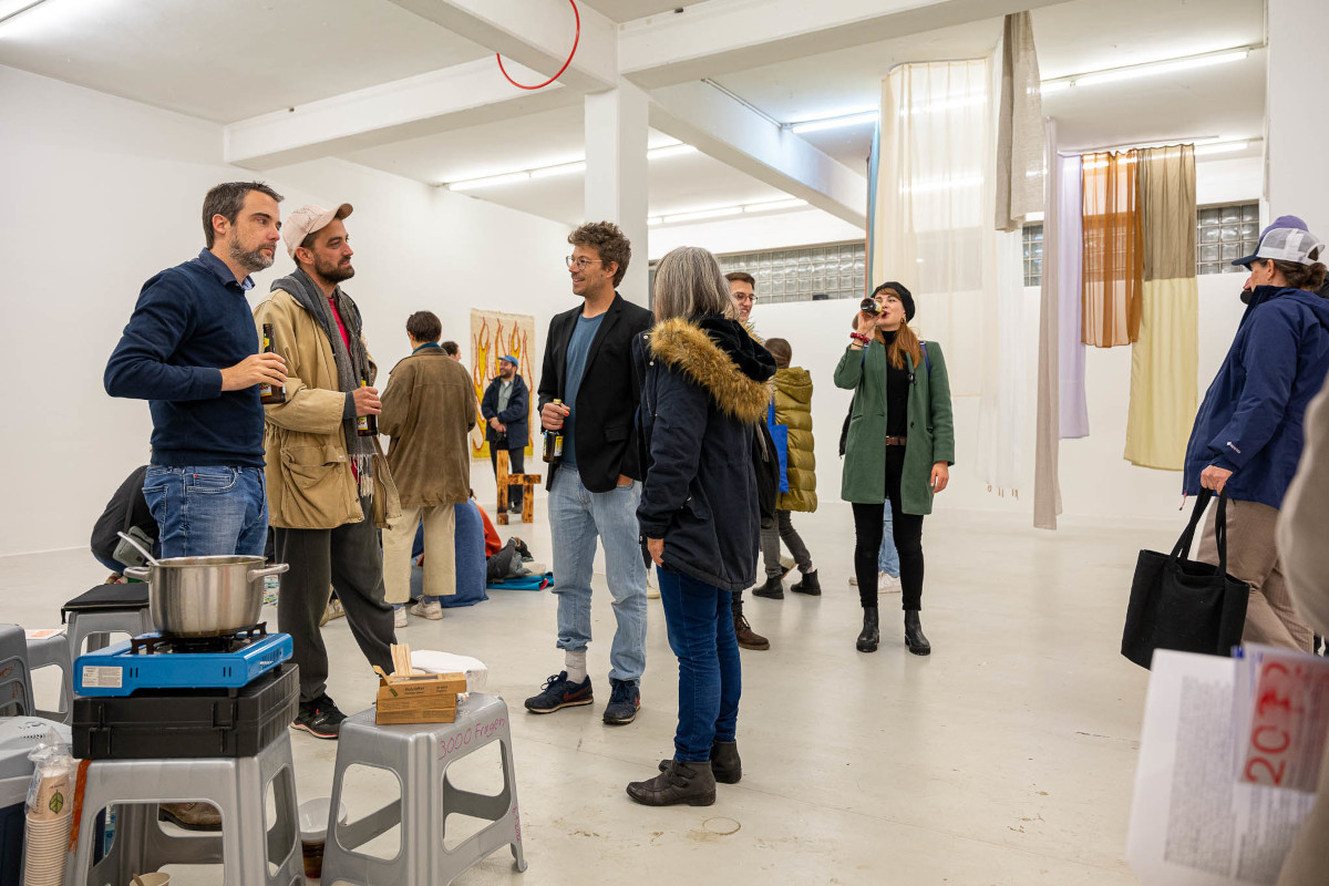 Ausstellungsansicht Vernissage, Menschen im Gespräch bei Nudelsuppe