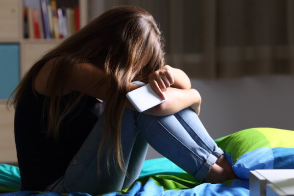 Frau sitzt traurig auf dem Boden