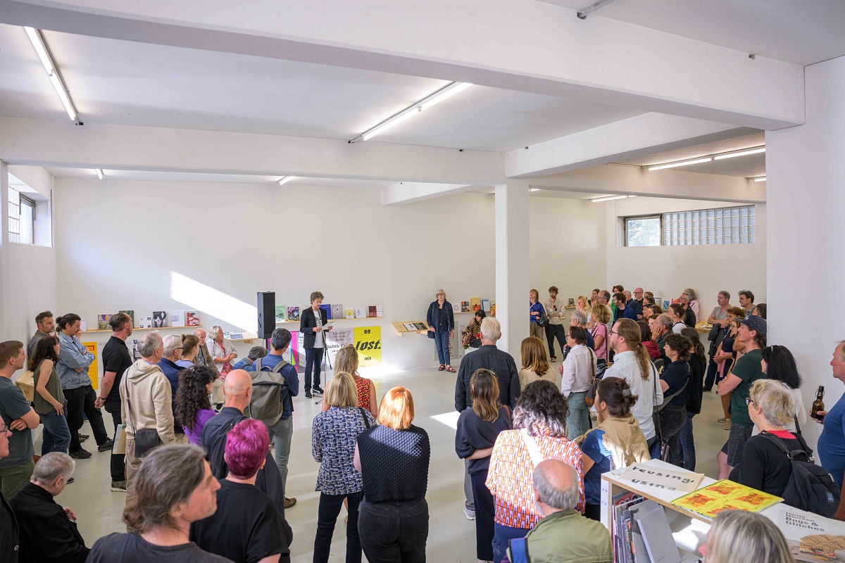 Eröffnung der Ausstellung "Abschied vom L6". Eröffnungs- bzw. Abschiedsrede von Samuel Dangel. Vielen Menschen verdecken die Katalogausstellung