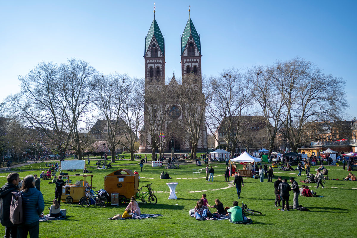 Schönes Wetter, Standort: Stühlinger Kirchplatz, viele Menschen sitzen im Grünen