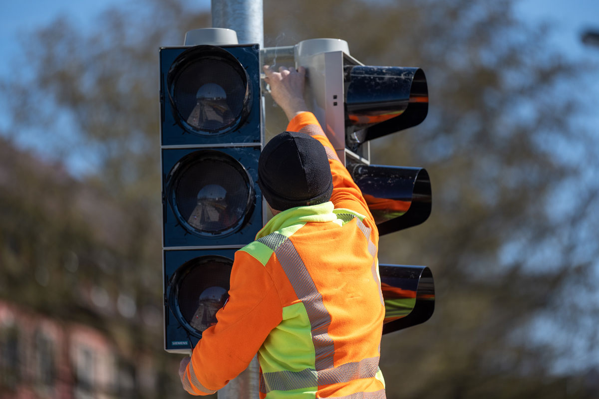Person schließt neue Ampel an