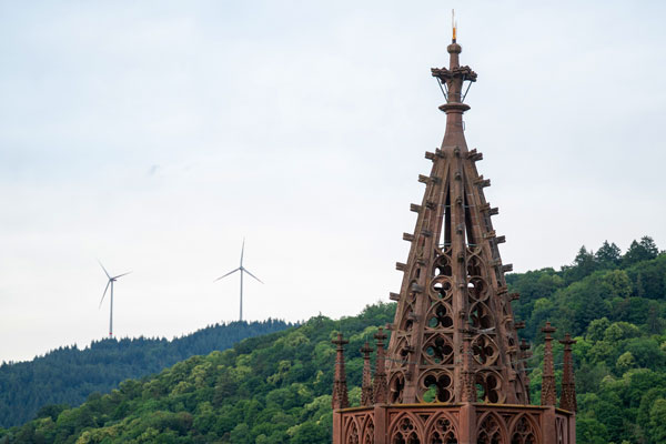 Münsterturm vor Berg mit Windrädern