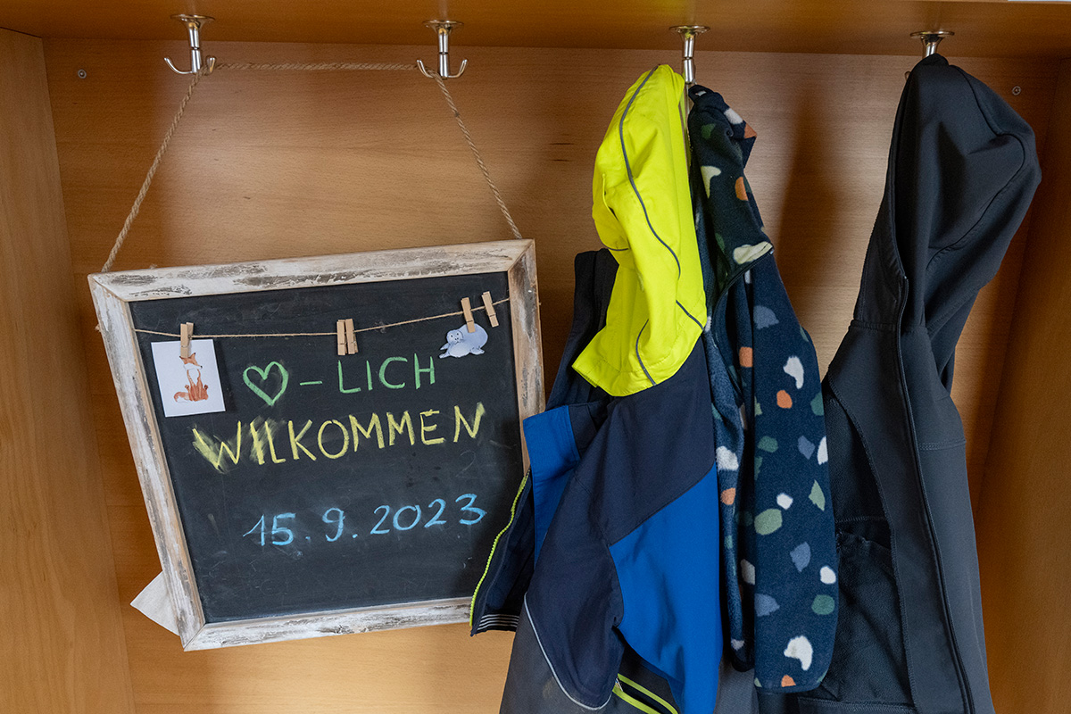 Garderobe mit einem Schild "herzlich willkommen"