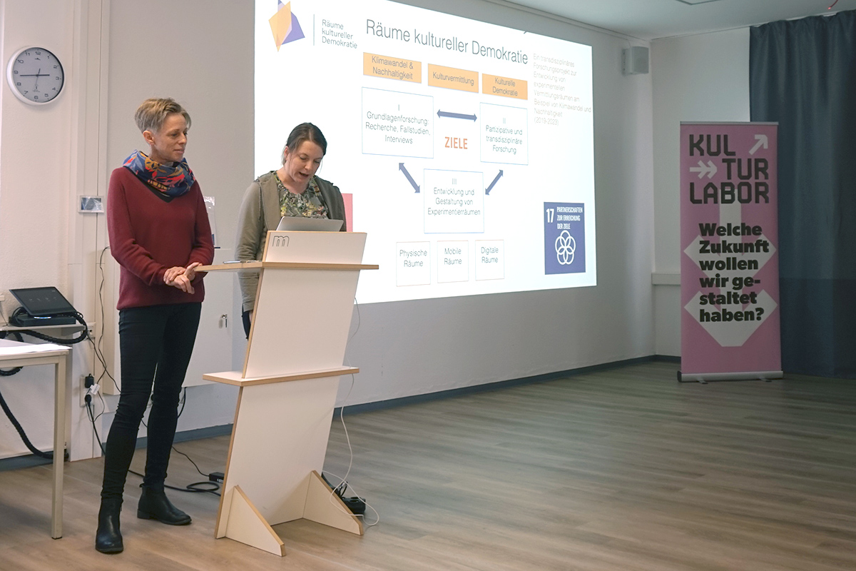 Zwei Referntinnen vor einem gebeamten Bild