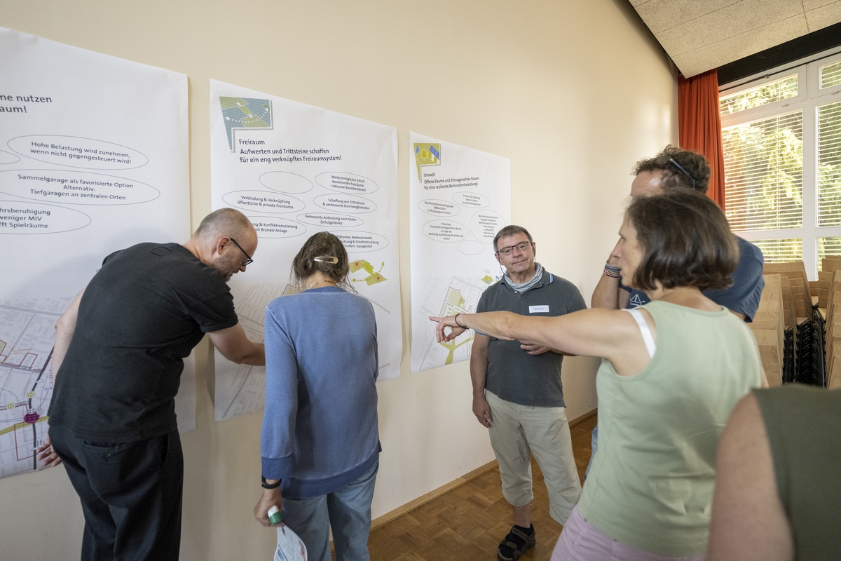 Mentschen schreiben etwas auf ein Poster an der Wand