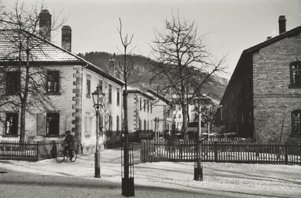 Schwarz-Weiß-Foto einer Staßenflucht 1929 mit zweigeschossigen Reihenhäusern