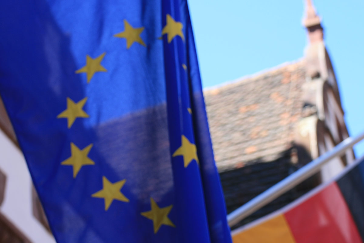 Nahaufnahme: Europäische Flagge und Deutsche Flagge an einem Gebäude