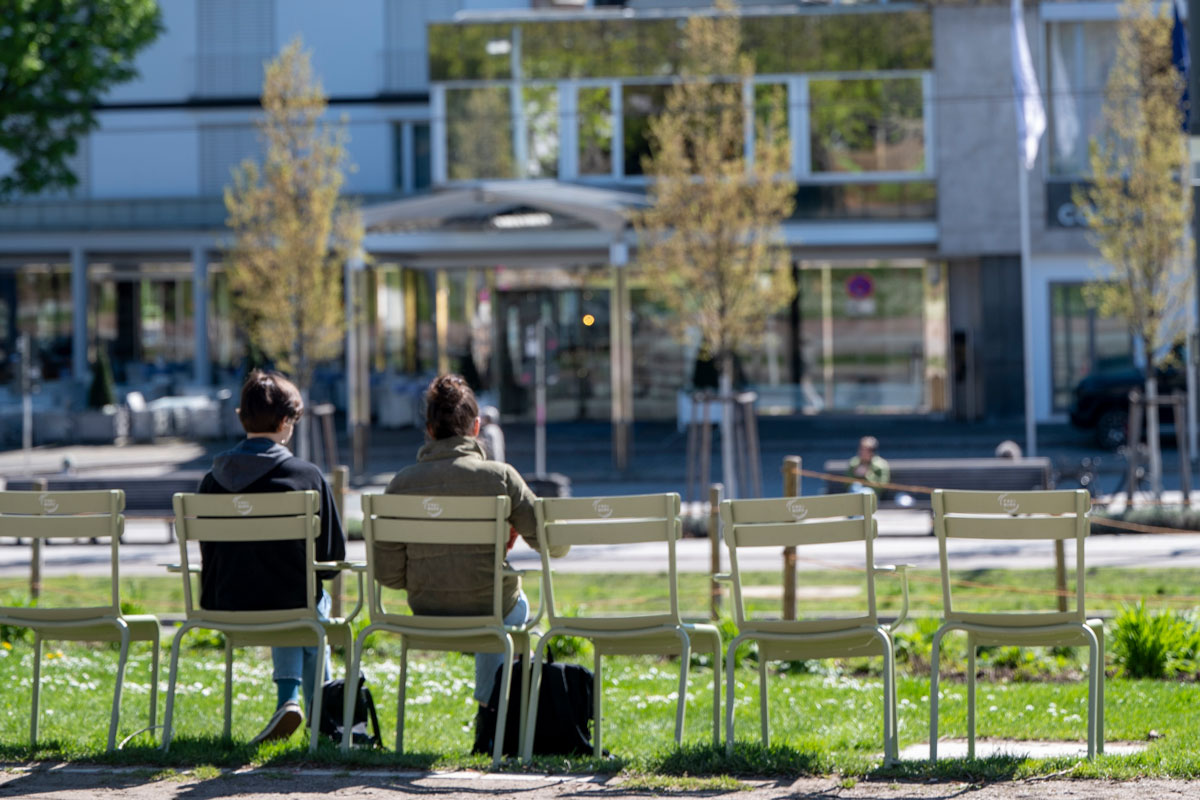 Zwei Personen sitzen auf grünen Stühlen im Colombipark, Innenstadt