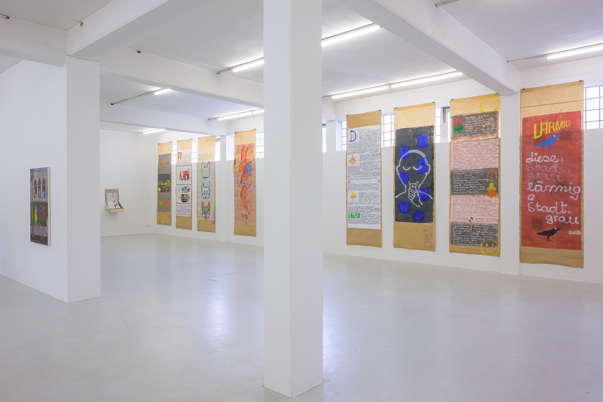 Ausstellungsansicht mit bemalten Packpapierbahnen